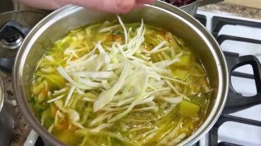 Patates ve havuçla dolu bir tencereye doğranmış lahana ekliyorum. Ukrayna borsası yapma süreci.
