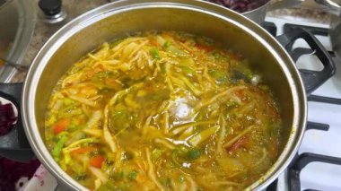 Patates, havuç, pırasa sapı, lahana ve tatlı biberle kaynayan bir kaba domates püresi ve doğranmış pancar ekliyorum. Ukrayna borsası yapma süreci.