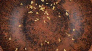 Bulgur Groats kahverengi bir seramik kaseye dökülür. Üst Manzara. Yavaş çekim.