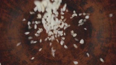 Yuvarlak pirinç kahverengi bir seramik kaseye dökülür. Üst Manzara. Yavaş çekim.