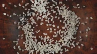 Yuvarlak pirinç kahverengi bir seramik kaseye dökülür. Üst Manzara. Yavaş çekim.