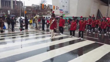 TORONTO, Kanada - 17 Mart 2025: Toronto, Ontario, Kanada 'da Aziz Patrick Günü Geçidi. Bir tören sırasında, parlak kırmızı üniformalı bir pirinç ve perküsyon grubu yürür..