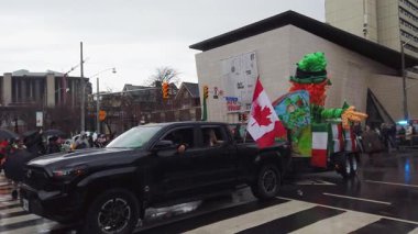 TORONTO, Kanada - 17 Mart 2025: Toronto, Ontario, Kanada 'da Aziz Patrick Günü Geçidi. Kanada ve İrlanda bayrakları ve balonlardan yapılmış büyük, parlak bir leprikonla geçit töreni şamandırası geçit törenine katılır..