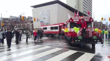 TORONTO, Kanada - 17 Mart 2025: Toronto, Ontario, Kanada 'da Aziz Patrick Günü Geçidi. NewBeaver Tapınak Kulübü üyeleri renkli kırmızı ve beyaz otobüslerdeki geçit törenine katılın..