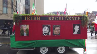 TORONTO, Kanada - 17 Mart 2025: Toronto, Ontario, Kanada 'da Aziz Patrick Günü Geçidi. Kanada ve İrlanda 'nın bayraklarını taşıyan katılımcılar neşeyle seyircilerin yanından geçip onları selamlıyor..