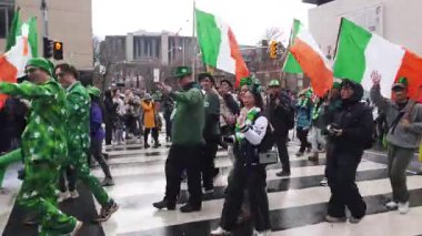 TORONTO, Kanada - 17 Mart 2025: Toronto, Ontario, Kanada 'da Aziz Patrick Günü Geçidi. Parlak kostümlü neşeli katılımcılar ve İrlanda bayraklarıyla yürüyüp seyircilere selamlarını sallıyorlar..