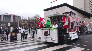 TORONTO, CanADA - 17 Mart 2025: Toronto, Ontario, Kanada 'da Aziz Patrick Günü geçit töreni. El Shamaly Tapınak Kulübü 'nün kırmızı-beyaz çizgili otobüsü ve Leitrit Birliği' nin katılımcıları..