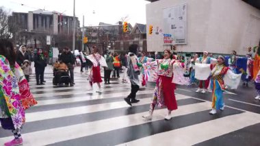 TORONTO, CanADA - 17 Mart 2025: Toronto, Ontario, Kanada 'da Aziz Patrick Günü geçit töreni. Renkli geleneksel Japon kostümleri içinde yürüyüş yapan katılımcılar yürürken dans ediyorlar..