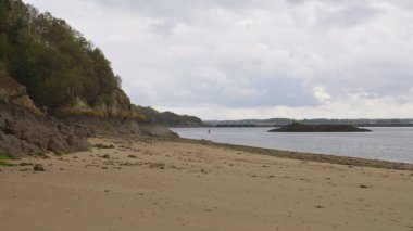 Ağaçlı kayalar, kumlu plajlar ve Corbiere Körfezi 'nde sudaki kayıklar Saint-Malo, Brittany, Fransa' da sular çekildiğinde.