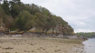 Ağaçlı kayalar, kumlu plajlar ve Corbiere Körfezi 'nde sudaki kayıklar Saint-Malo, Brittany, Fransa' da sular çekildiğinde.