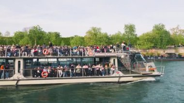 PARIS, FRANCE - 18 Nisan 2025: Birçok turisti taşıyan bir nehir yolcu gemisi baharda Paris 'teki Seine Nehri' nden geçiyor.
