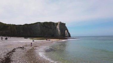 Plage dEtretat plajı alçak sular, tebeşir kayalıkları, doğal kemerler, Porte d 'Aval, doğal kemerler ve uçurum L' Aiguille in Etretat Tebeşir Kompleksi ilkbaharda güneşli bir günde, la Manche Kanalı (İngiliz Kanalı), Normandiya, Fransa.