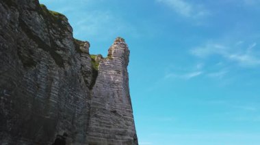 ETRETAT, FRANCE - APRIL 22, 2025: Beyaz tebeşir uçurumlarının panoramik görünümü, noktalı oluşum, güneşli bahar gününde Etretat Tebeşir Kompleksi 'nde kayalık bir plajda yürüyen turistler, la Manche Kanalı (İngiliz Kanalı), Normandiya, Fransa.