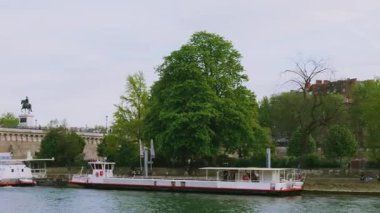 Seine Nehri manzarası, ada de Cite, insanlar Square du Vert-Galant 'da nehir kıyısında dinleniyor, 1. bölge, Paris, Fransa.