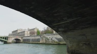 Sen nehri kıyısında bir tekne gezisi. Fransa, Paris 'teki Seine Nehri üzerindeki Pont au Change köprüsünün altından bir tekne geçiyor. Köprü birinci ve dördüncü arrondissements arasındaki sınırda yer almaktadır..