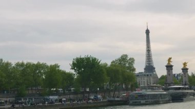 PARIS, FRANCE - 21 NİSAN 2025: Seine Nehri manzarası, set seti, tek kemerli köprü Pont Alexandre III, Eyfel Kulesi ve akşam gökyüzüne doğru giden bir tekne.. 