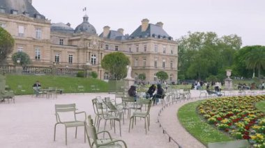 PARIS, FRANCE - 21 Nisan 2025: Orta çimenliğe, Primula yataklarına, Lüksemburg Sarayı 'na, Büyük Havza' ya ve turistlerin yeşil metal koltuklarda dinlenip, güneşli bir bahar gününde Lüksemburg Bahçesi 'nde 6..