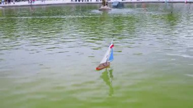 Fransa bayrağı direkte olan, Lüksemburg Bahçeleri 'ndeki Büyük Havza' da beyaz ve mavi yelkenli model bir yelkenli, Paris, Fransa 'da 6. Tuileries Garden 'da bulunanlara benziyor..