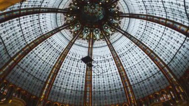 PARIS, FRANCE - 19 Nisan 2025: Neo Bizans Kubbesi 'nin içeriden görüşü, Art Deco tarzı interio tasarımı ve üst düzey Fransız mağazası Galerisi Lafayette Haussmann' ın ziyaretçileri.