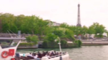 Sen nehri kıyısında bir tekne gezisi. Eyfel Kulesi manzarası ve yanından geçen turistlerle dolu çift katlı bir tekne. Paris, Fransa. Odaklanamıyorum.