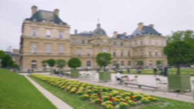 Lüksemburg Sarayı manzarası, ilkbahar Primula yatakları ve turistler. Lüksemburg Bahçeleri, 6. Bölge, Paris. Odaklanamıyorum. Paris, Fransa.
