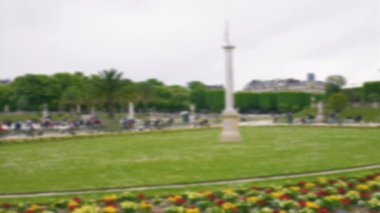 Lüksemburg Sarayı, Büyük Havza 'nın panoramik manzarası, yeşil metal koltuklarda dinlenen turistler ve Paris' in 6. semtinde güneşli bir bahar gününde Lüksemburg Bahçesinde gezinen turistler. Odaklanamıyorum. Paris, Fransa.