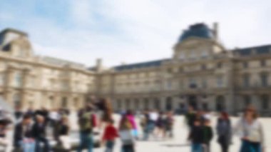 Birçok turist Louvre Sarayı 'nın (Cour Napoleon) ana avlusunda gezinir, bakar ve fotoğraf çeker, açık güneşli bir baharda ünlü Louvre Piramidi de dahil. Paris, Fransa. Odaklanamıyorum.
