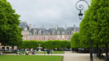 Dört Cortot çeşmesinden biri olan ıhlamur yataklarının panoramik manzarası Vosges Meydanı 'nın köşelerinde eski tarihi binalara ve çiçek açan kestane ağaçlarına karşıdır. Paris, Fransa. Odaklanamıyorum.