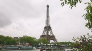 Seine Nehri 'nin sağ kıyısından Eyfel Kulesi manzarası ve Fransa' nın başkenti Paris 'te turistlerle dolu bir feribot..
