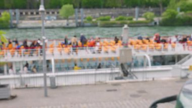 İnsanlar Paris, Fransa 'daki Seine Nehri boyunca yapılacak bir gemi gezisi için çift katlı bir turist feribotunun güvertesindeki koltuklarına oturuyorlar. Odaklanamıyorum.