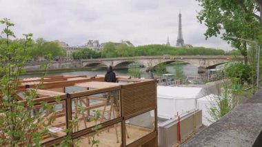 İşçiler Seine nehrinin sağ kıyısındaki toprak setine yeni pavyonun ahşap yapılarını dikiyorlar. Pont des Invalides ve Eyfel Kulesi, Paris, Fransa.