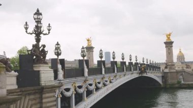 Pont Alexandre Köprüsü 'nün manzarası zarif dekorları ve güzel sokak lambalarıyla Seine Nehri üzerinde ve Fransa' nın sol kıyısındaki Invalides Evi..