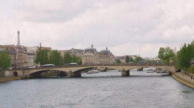Paris, Fransa 'da bulutlu bir bahar gününde Seine Nehri, Pont du Atlıkarınca Köprüsü ve Eyfel Kulesi manzarası.