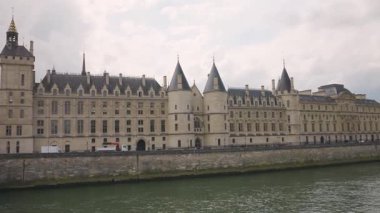 Paris, Fransa 'da bulutlu bir bahar gününde Seine Nehri, Conciergerie Sarayı, Pont Neuf Köprüsü ve Rue Voie Georges Pompidou' nun yayaları görülüyor..