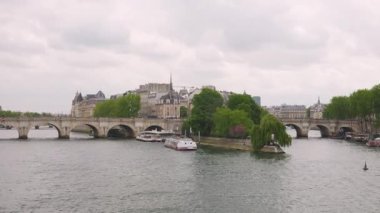 Seine nehri manzarası, Pont Notre Dame köprüsü, katedral kilise Notre-Dame de Paris ve Fransa 'nın Paris şehrinde bulutlu bir bahar gününde bir yolcu gemisi..