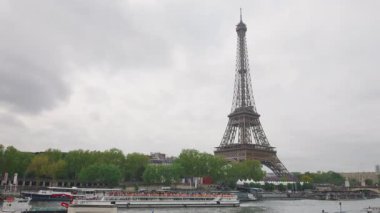 Seine Nehri 'nin sol kıyısına, Eyfel Kulesi' ne, nehirde yelken açan teknelere, bulutlu bir bahar gününde Paris, Fransa 'nın 7..