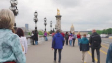 İnsanlar Fransa 'nın Paris kentindeki Pont Alexandre III köprüsünden Seine Nehri' ni geçiyor. Odaklanamıyorum. Yavaş çekim.