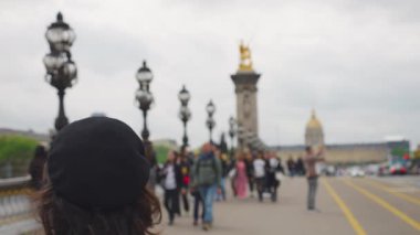 Pont Alexandre Köprüsü 'ndeki Bereliler ve diğer yayalar Fransa' nın başkenti Paris 'teki Seine Nehri' ni geçiyor. Odaklanamıyorum. Yavaş çekim.