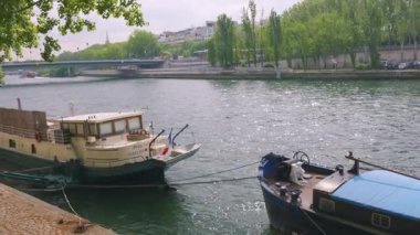 PARIS, FRANCE - 21 Nisan 2025: güneşli bir bahar gününde Seine Nehri 'nin sağ kıyısında demirlemiş motorlu botlar.