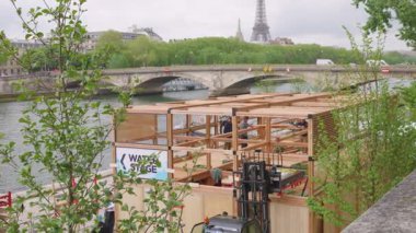 PARIS, FRANCE - 21 Nisan 2025 Seine nehrinin sağ kıyısındaki toprak setinde yeni ahşap pavyonun inşaatı. Pont des Invalides ve Eyfel Kulesi 'nin manzarası.