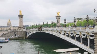 PARIS, FRANCE - 21 Nisan 2025: Seine Nehri üzerindeki Pont Alexandre III köprüsü ve sağ kıyıdaki Invalides Evi manzarası.