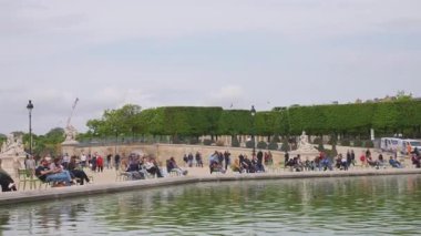 PARIS, FRANCE - 21 Nisan 2025: İnsanlar Jardin des Tuileries (Tuileries Bahçesi) 'ndeki Bassin Octogonal etrafında yürür, rahatlar ve koşar..