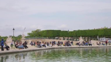 PARIS, FRANCE - 21 Nisan 2025: İnsanlar Jardin des Tuileries (Tuileries Bahçesi) 'ndeki Bassin Octogonal etrafında yürür, rahatlar ve koşar..