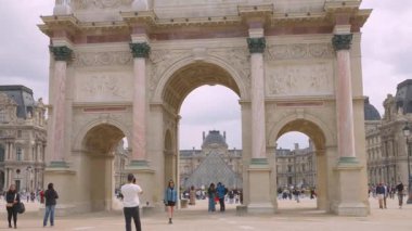 PARİS, FRANCE - 21 Nisan 2025: İnsanlar Atlıkarınca Meydanı boyunca yürüyüp güneşli bir bahar gününde Zafer Takı 'nın önünde fotoğraf çekiyorlar..