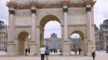 PARİS, FRANCE - 21 Nisan 2025: İnsanlar Atlıkarınca Meydanı boyunca yürüyüp güneşli bir bahar gününde Zafer Takı 'nın önünde fotoğraf çekiyorlar..
