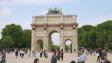 PARIS, FRANCE - 21 Nisan 2025: İnsanlar güneşli bir bahar gününde Atlıkarınca Meydanı 'nda Zafer Takı ve Jardin du Atlıkarınca manzarası ile gezinirler..