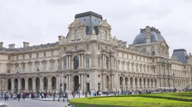 PARİS, FRANCE - 21 Nisan 2025: İnsanlar yürüyor ve turistler ve arabalarla birlikte çift katlı turist otobüsü ilk arrondissement meydanında kamu meydanı du Carrousel 'de ilerliyor.