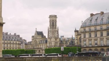 PARIS, FRANCE - 21 Nisan 2025 Quai Francois Mitterrand 'ın karşısındaki Saint-Germain l' Auxerrois Kilisesi bulutlu bir bahar gününde ilk arrondissement.