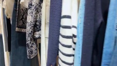 Fransa, Paris 'teki popüler mağazalardan birinde giysi rafları boyunca hızlı bir yürüyüş..