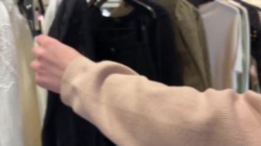 Bir kız, istediği şeyi seçebilmek için birkaç modele bakıyor. Üst sınıf Fransız mağazası Galerisi Lafayette Haussmann, Paris, Fransa.